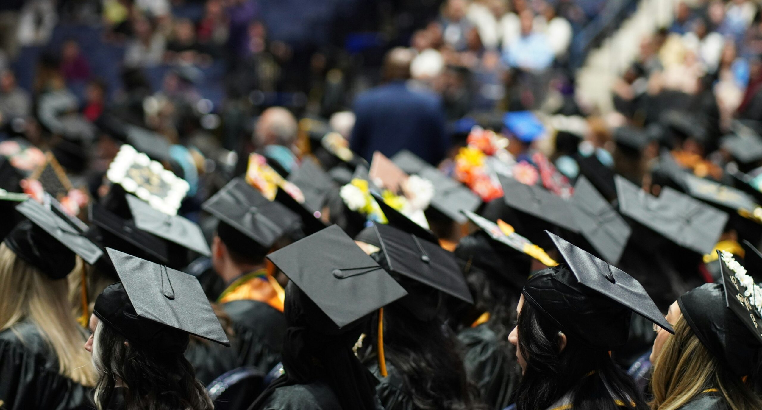 Graduates in caps and gowns seated at a commencement ceremony